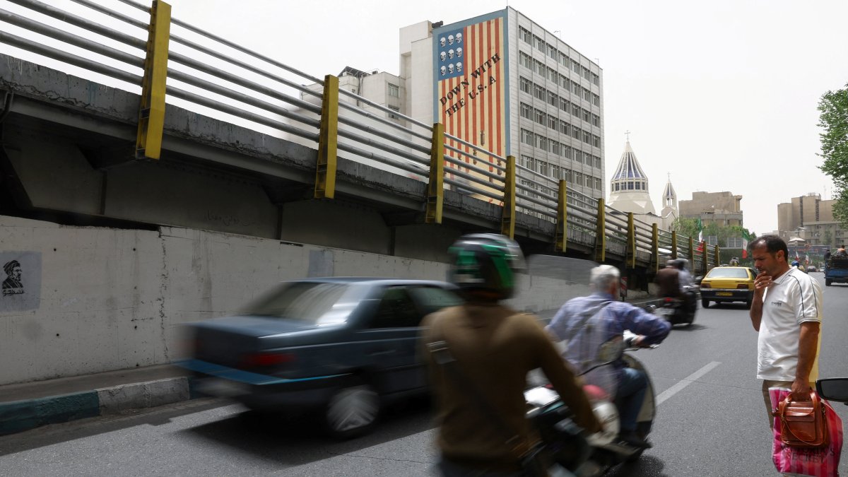 People drive near an anti-U.S. mural on a building in Tehran, Iran, May 19, 2026. (Reuters Photo)