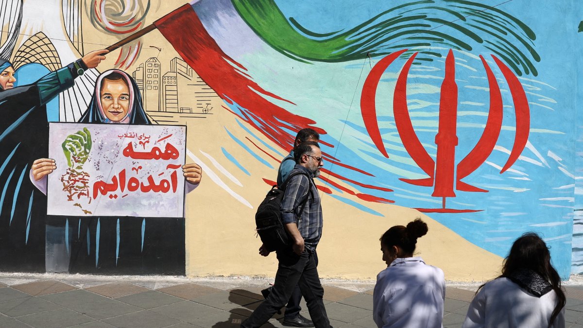 People walk next to a mural on a street in Tehran, Iran, May 18, 2026. (Reuters Photo)