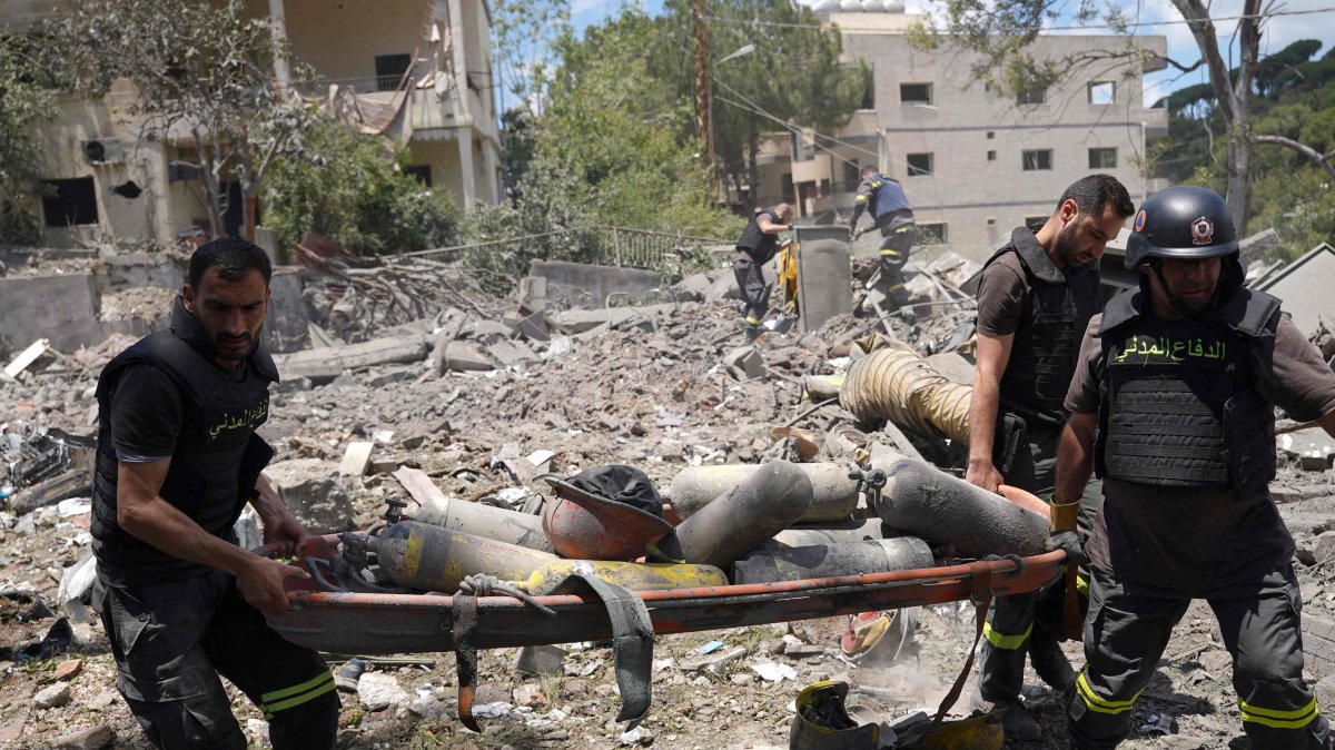 Emergency workers use a stretcher to remove oxygen bottles from under the debris of a civil defense center damaged in an Israeli air strike on the southern city of Nabatiyeh, Lebanon, May 24, 2026. (AFP Photo)