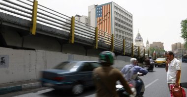 People drive near an anti-U.S. mural on a building in Tehran, Iran, May 19, 2026. (Reuters Photo)