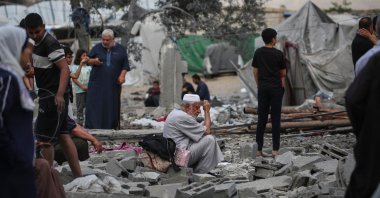 A Palestinian man sits on the rubble at the site of a residential building targeted overnight by an Israeli strike, in Deir al-Balah, central Gaza Strip, May 24, 2026. (AFP Photo)