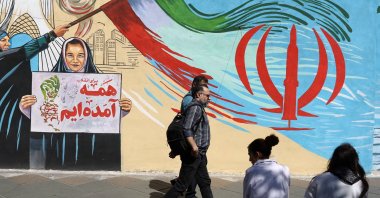 People walk next to a mural on a street in Tehran, Iran, May 18, 2026. (Reuters Photo)