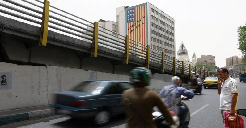 People drive near an anti-U.S. mural on a building in Tehran, Iran, May 19, 2026. (Reuters Photo)