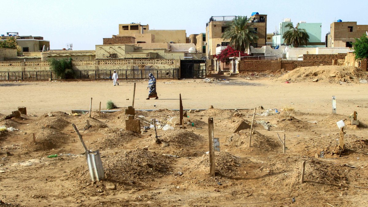 A Sudanese woman walks past graves of people killed during clashes lining the streets of Omdurman, Sudan, March 20, 2025. (AFP Photo)