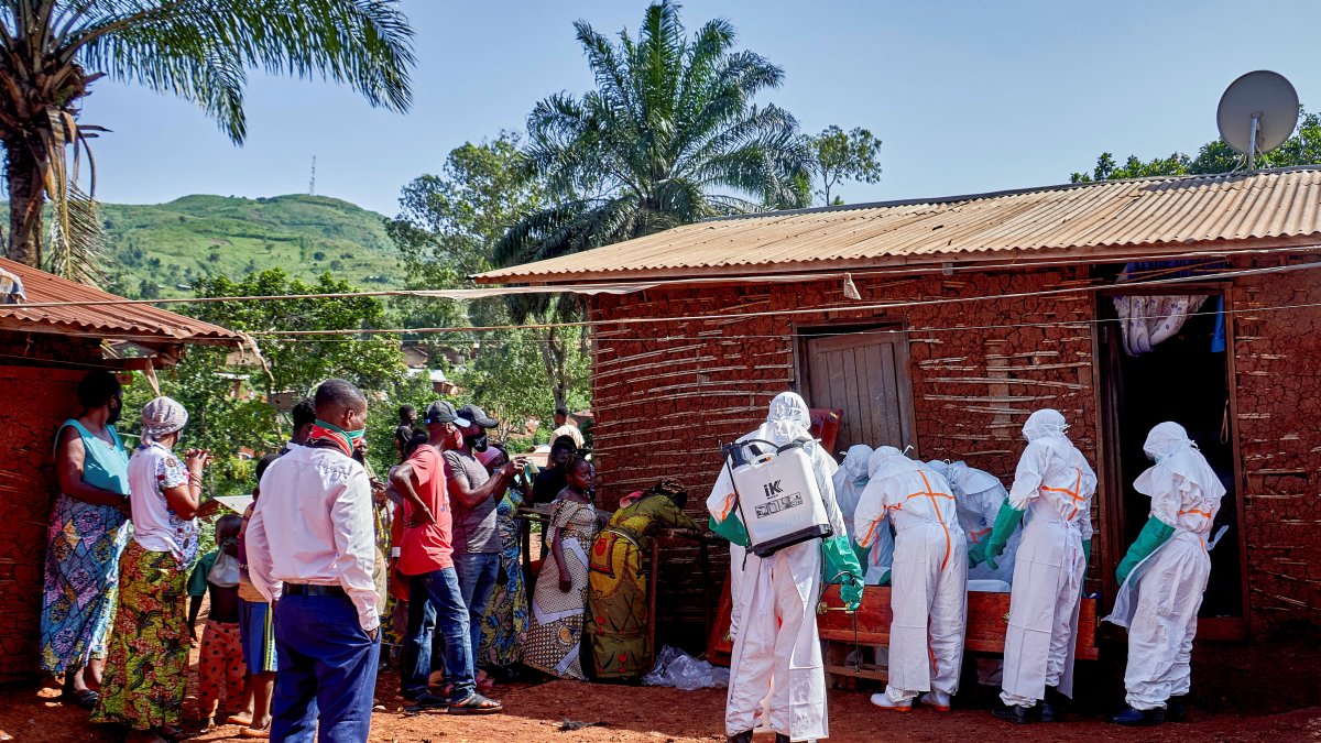 Red Cross workers wearing personal protective equipment (PPE) place into a wooden coffin the body of a man, who died of Ebola, after retrieving the body from his house, as aid agencies intensify efforts to contain a new Ebola outbreak involving the Bundibugyo strain, in Quartier Shuni 1, a residential sector, Mongbwalu, DRC, May 24, 2026. (Reuters Photo)
