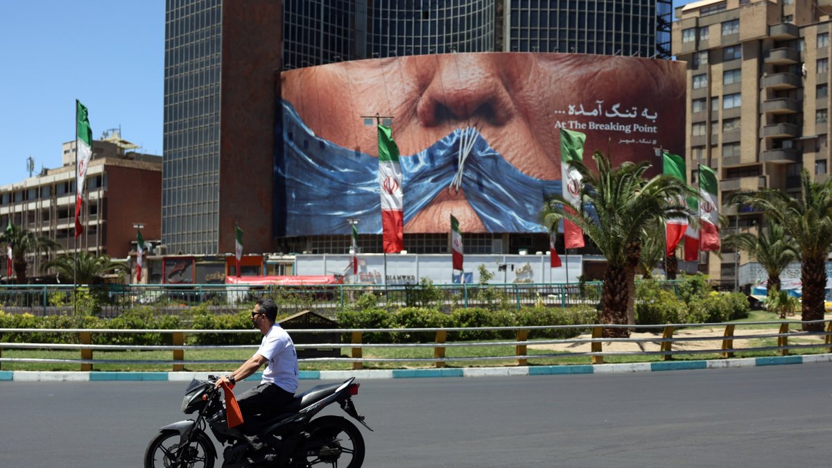 People drive in front of a large anti-U.S. billboard featuring U.S. President Donald Trump and the Strait of Hormuz at Valiasr Square in Tehran, Iran, May 25, 2026. (EPA Photo)