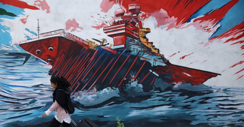 An Iranian woman walks next to a mural on a street, Tehran, Iran, May 11, 2026. (Reuters Photo)