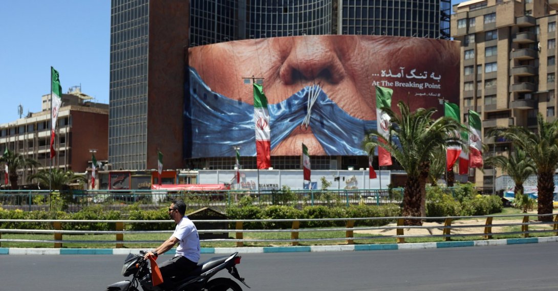 People drive in front of a large anti-U.S. billboard featuring U.S. President Donald Trump and the Strait of Hormuz at Valiasr Square in Tehran, Iran, May 25, 2026. (EPA Photo)