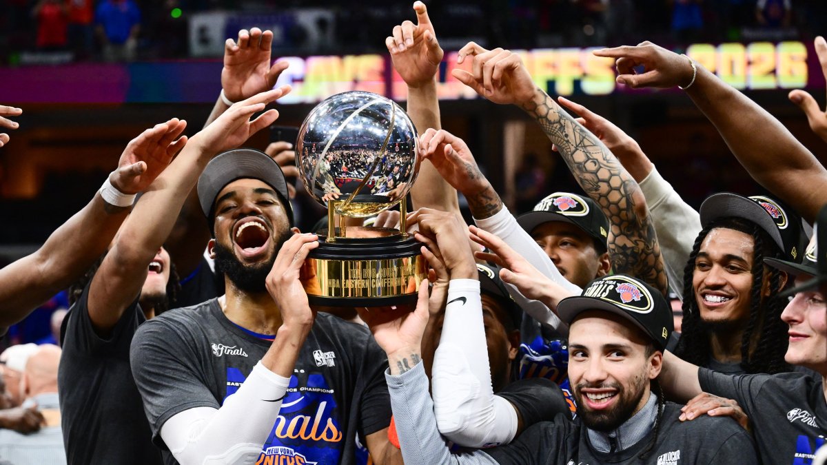 New York Knicks' Karl-Anthony Towns (L) and Jose Alvarado (R) help the team lift the trophy after defeating the Cleveland Cavaliers in game four of the Eastern Conference Finals for the 2026 NBA playoffs at Rocket Arena, Cleveland, U.S., May 25, 2026. (Reuters Photo)