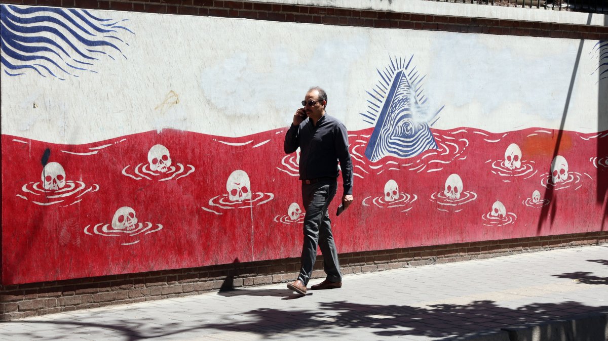 An Iranian man walks next to an anti-U.S. mural near the former U.S. embassy in Tehran, Iran, May 26, 2026. (EPA Photo)