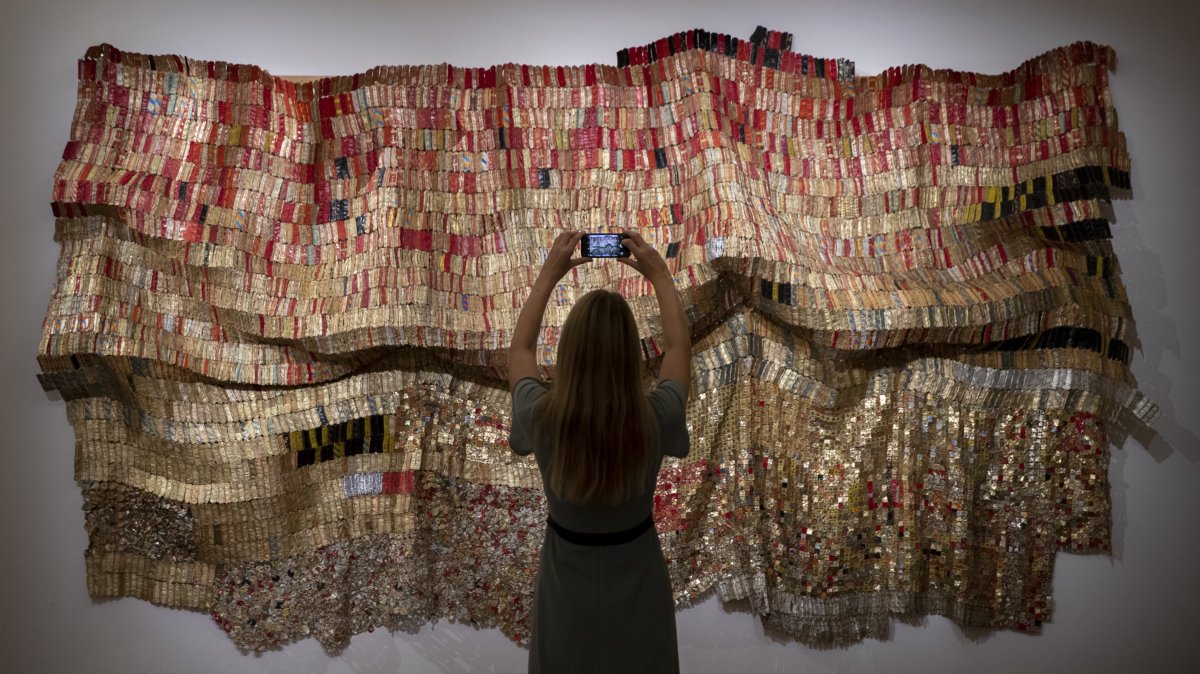 A gallery technician takes a photo of work titled "Vumedi" by artist El Anatsui from the "Modern &amp; Contemporary African Art" exhibition ahead of Sotheby’s online auction, London, U.K., Oct. 2, 2020. (Getty Images Photo)