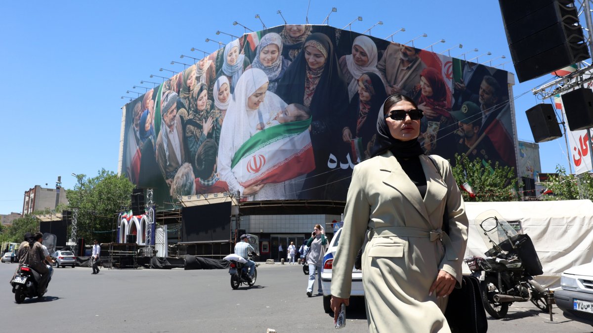 A woman walks next to a huge billboard in a street in Tehran, Iran, May 25, 2026. (EPA Photo)