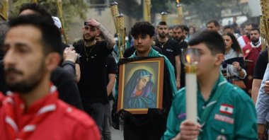A boy carries a symbol of the Virgin Mary during the Good Friday procession near Saint Maroun Church in the Shiyah neighborhood, Beirut, Lebanon, May 3, 2026. (Shutterstock Photo)