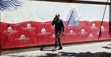 An Iranian man walks next to an anti-U.S. mural near the former U.S. embassy in Tehran, Iran, May 26, 2026. (EPA Photo)