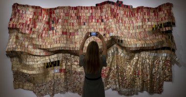 A gallery technician takes a photo of work titled "Vumedi" by artist El Anatsui from the "Modern &amp; Contemporary African Art" exhibition ahead of Sotheby’s online auction, London, U.K., Oct. 2, 2020. (Getty Images Photo)