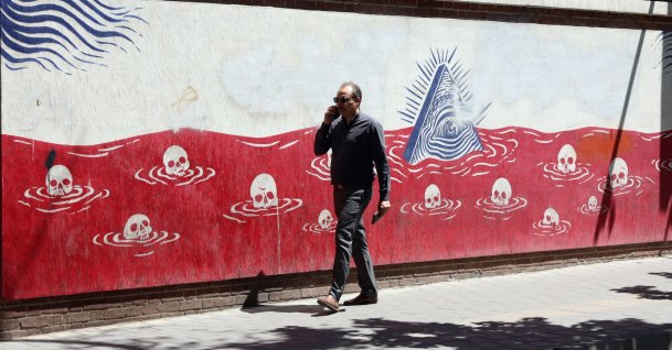 An Iranian man walks next to an anti-U.S. mural near the former U.S. embassy in Tehran, Iran, May 26, 2026. (EPA Photo)