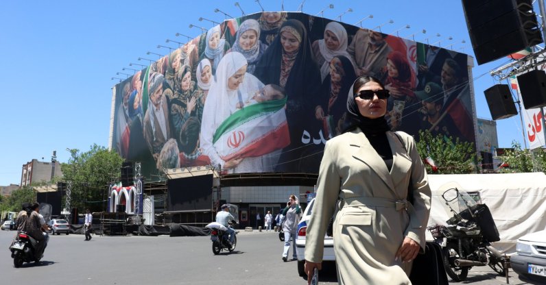 A woman walks next to a huge billboard in a street in Tehran, Iran, May 25, 2026. (EPA Photo)