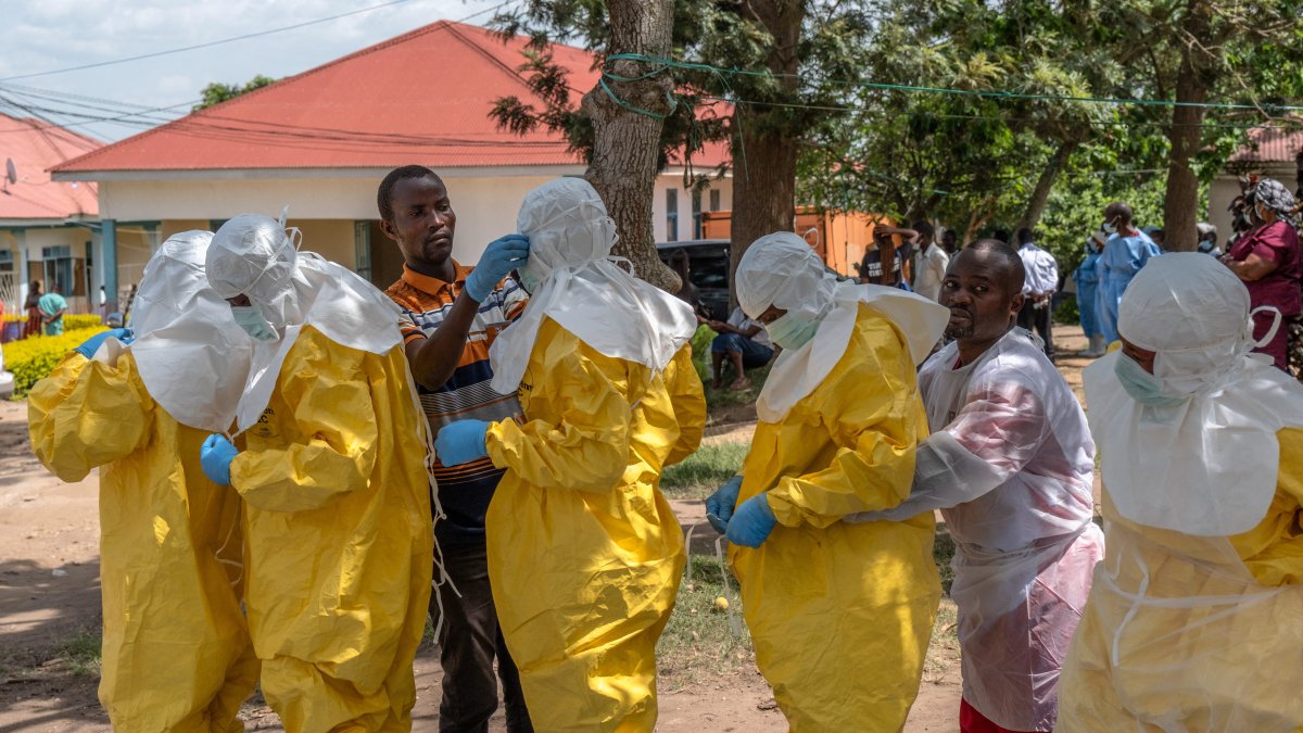 Red Cross workers dress in personal protective equipment (PPE) before handling the body of Dr Tibenderana Katho Blaise who worked at the Centre Medical Evangelique (CME) in Hoho commune and died of Ebola virus, as aid agencies intensify efforts to contain a new Ebola outbreak caused by the Bundibugyo virus, ahead of his burial in Bunia town, Ituri province, DRC, May 27, 2026. (Reuters Photo)