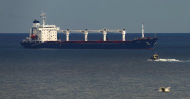 A boat with Russian, Ukrainian, Turkish and U.N. officials heads to the Sierra Leone-flagged cargo ship Razoni, to check if the grain shipment is in accordance with a crucial agreement signed last month by Moscow and Kyiv, at an inspection area in the Black Sea off the coast of Istanbul, Türkiye, Aug. 3, 2022. (AP Photo)