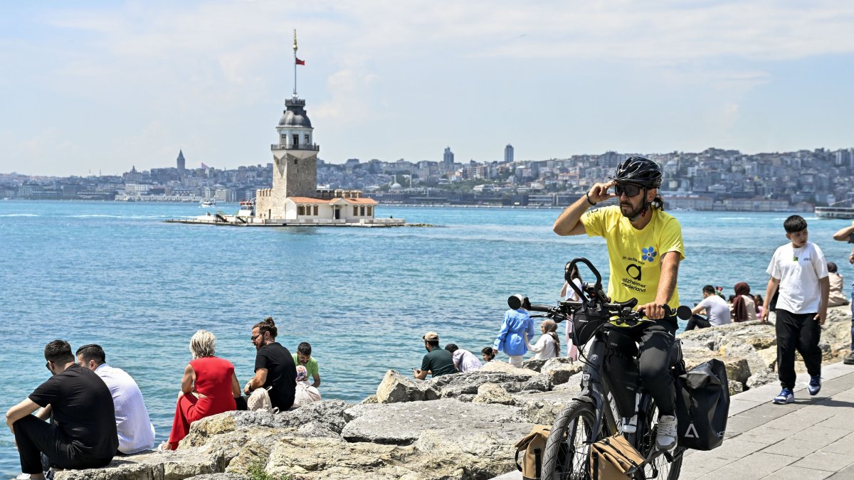 Semih Gürbüz poses with his bicycle near Kız Kulesi after completing a seven-country journey, Istanbul, Türkiye, May 28, 2026. (AA Photo)