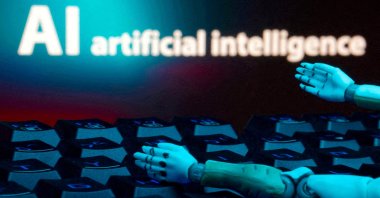A message reading "AI artificial intelligence," a keyboard and robot hands are seen in this illustration created on Jan. 27, 2025. (Reuters Photo)