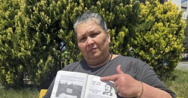 Sevinç Deniz holds a note about her father, a victim of Bulgaria's 1980s assimilation campaign against the Turkish minority, during an interview in Kocaeli, Türkiye, May 28, 2026. (AA Photo)