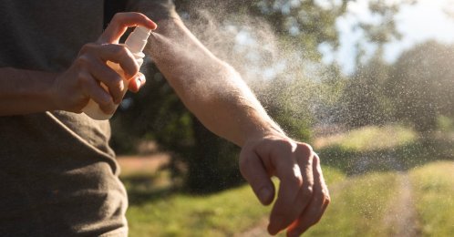 A man applies insect repellent on his arm. (Shutterstock Photo)