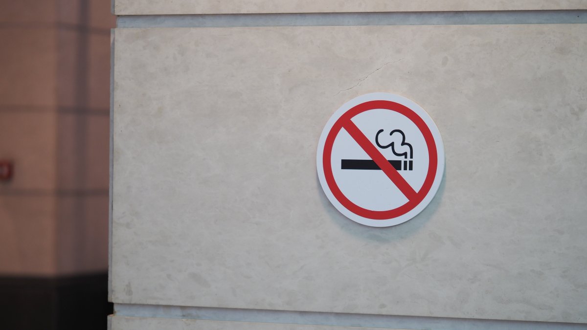 A no-smoking sign is displayed on a wall in a public area. (Shutterstock Photo)