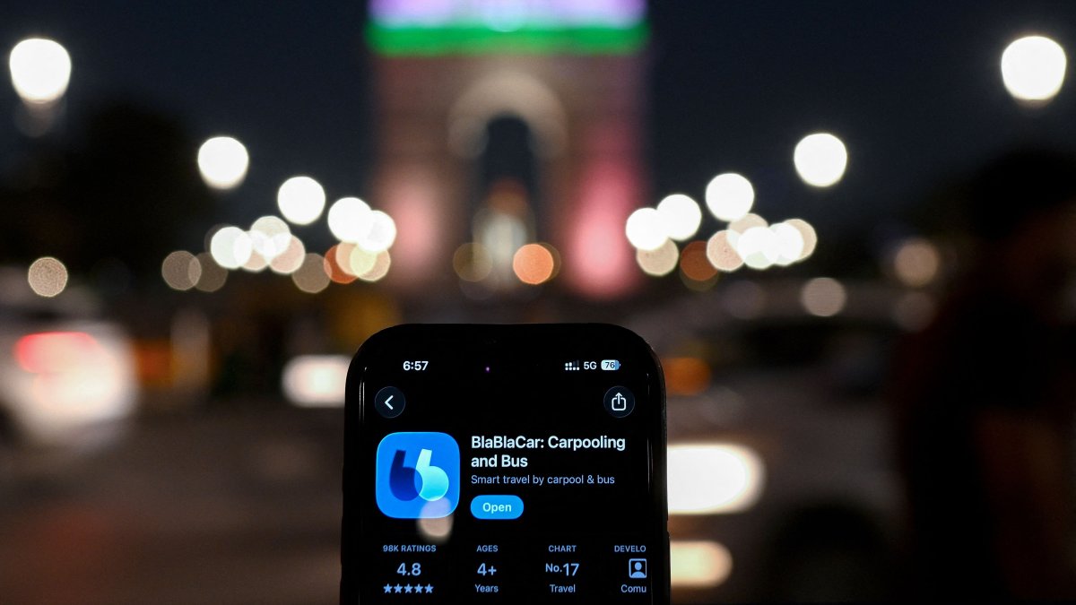 This illustration photograph shows ride-sharing platform BlaBlaCar mobile application on a smartphone against the backdrop of the India Gate in New Delhi, India, March 11, 2026. (AFP Photo)