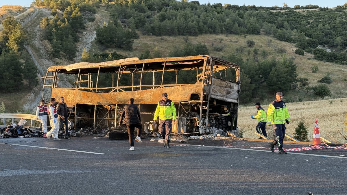 Police officers stand next to the damaged bus at the site of an accident after it crashed into highway barriers in Denizli province, Türkiye, May 31, 2026. (AA Photo)