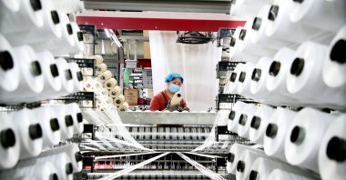 A worker monitors products for export at a packaging factory in Lianyungang, China, May 18, 2026. (AFP Photo)