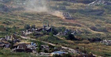 This picture taken from a position in the Upper Galilee region in northern Israel shows an Israeli tank taking position amid destroyed buildings in southern Lebanon, May 31, 2026. (AFP Photo)