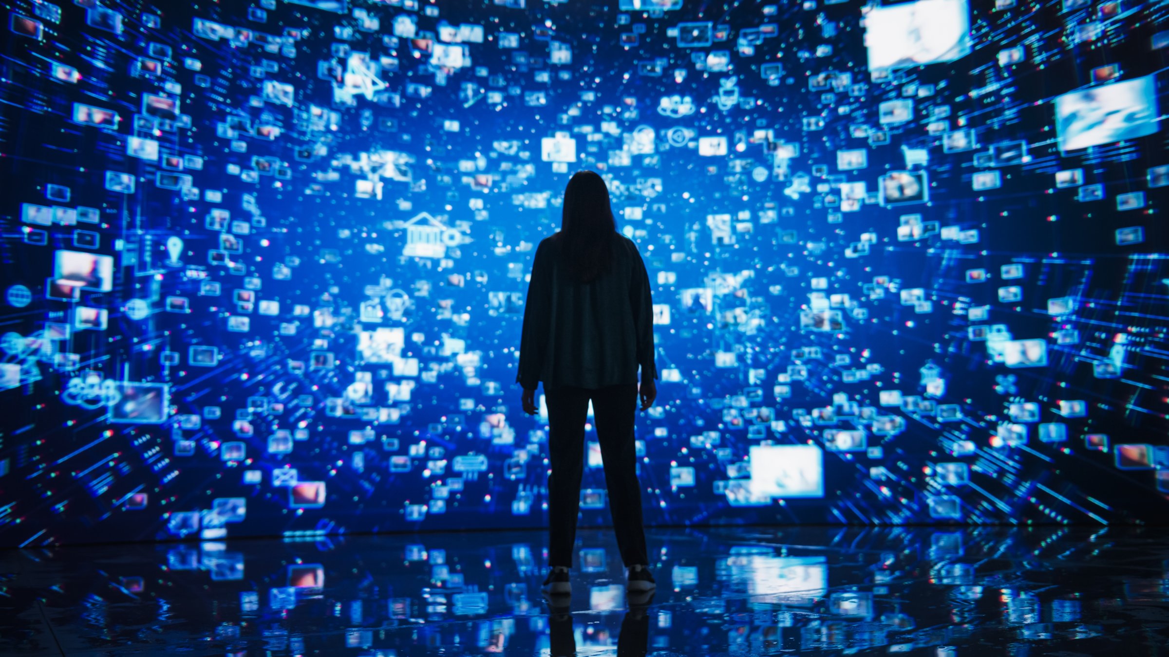 A young woman standing before a dynamic digital screen. (Shutterstock Photo)