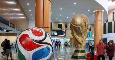Passengers look at a giant model of the football called "Trionda" and a replica of the World Cup trophy, which are displayed at Mexico City International Airport, ahead of the World Cup starting on June 11, Mexico City, Mexico, May 15, 2026. (Reuters Photo)