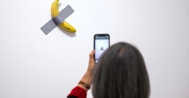 A visitor looks at the "Comedian" artwork by Italian artist Maurizio Cattelan during the press preview of the exhibition "Dimanche sans fin. Maurizio Cattelan et la Collection du Centre Pompidou," Metz, France, May 7, 2025. (AFP Photo)