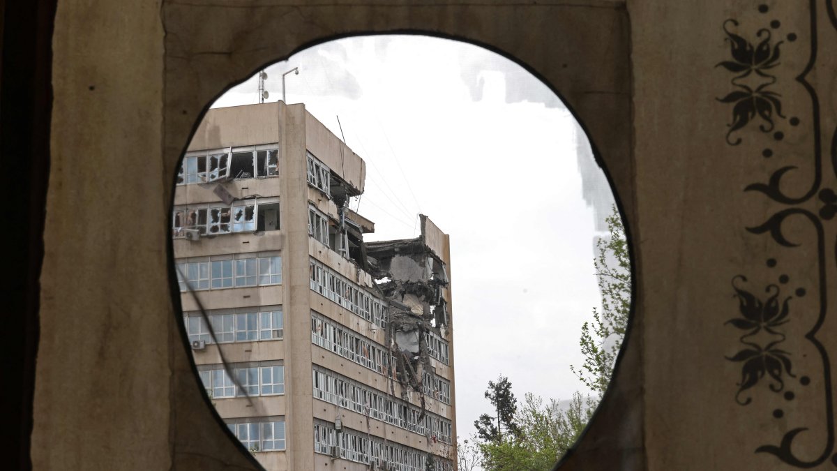 A building damaged by recent strikes is pictured through a curtain placed on the partial exterior of the historic Golestan Palace, Tehran, Iran, April 4, 2026. (AFP Photo)