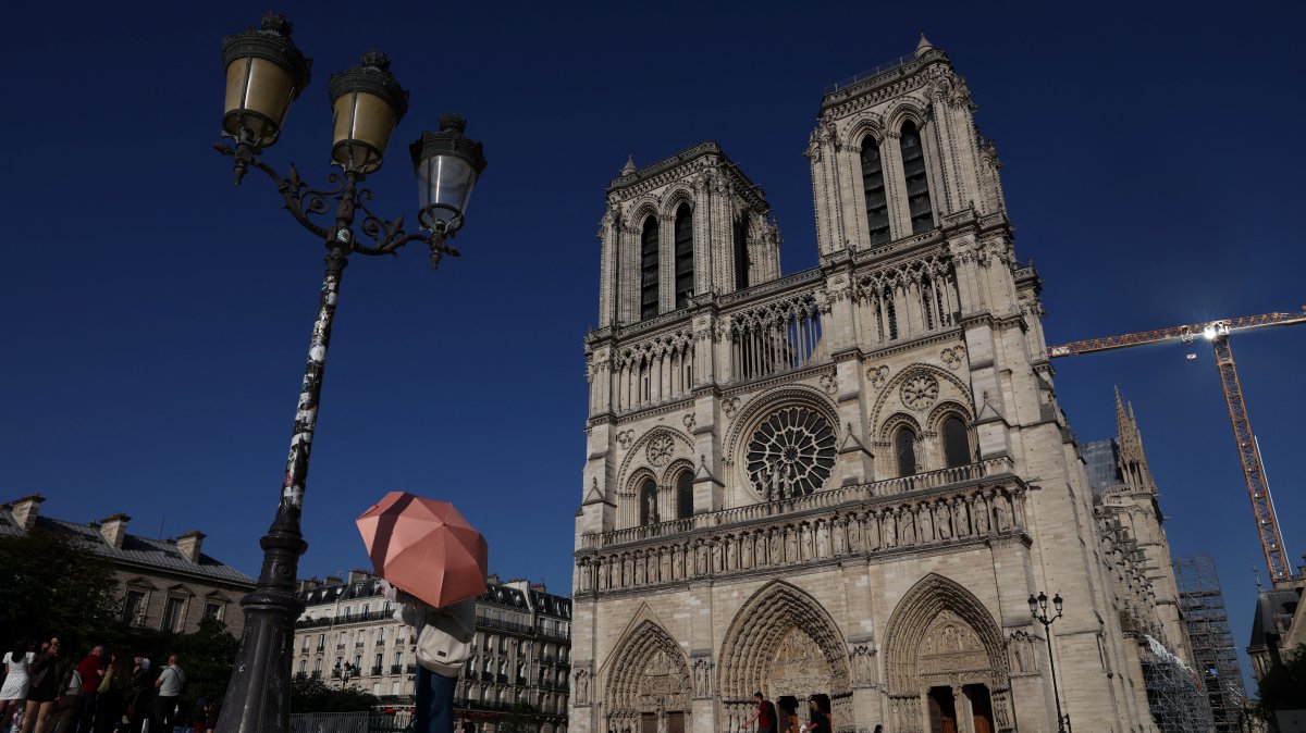 A person shelters under an umbrella outside Notre-Dame Cathedral amid a severe heat wave, Paris, France, May 26, 2026. (Reuters Photo)