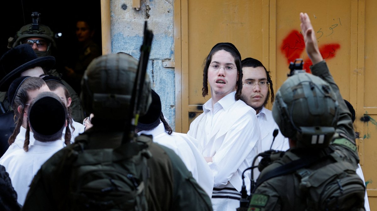 Israeli settlers stand next to Israeli soldiers during a weekly settlers' tour in Hebron, in the Israeli-occupied West Bank, Palestine, May 9, 2026. (Reuters Photo)