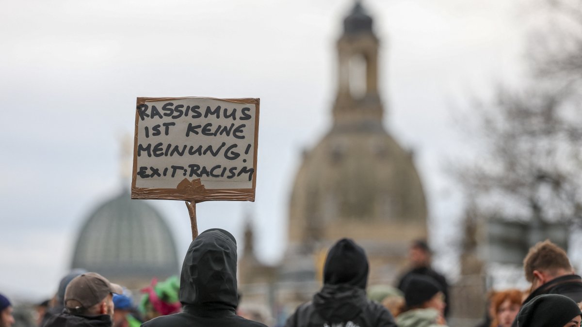 Demonstrators hold a sign reading "Racism is not an opinion! Exit: Racism" Saxony, Dresden, Oct. 28, 2025. (dpa Picture-Alliance via AFP)