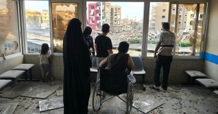 People look through damaged hospital windows at the site of an Israeli strike that hit near the hospital in Tyre, southern Lebanon, June 1, 2026. (AFP Photo)