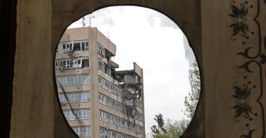 A building damaged by recent strikes is pictured through a curtain placed on the partial exterior of the historic Golestan Palace, Tehran, Iran, April 4, 2026. (AFP Photo)