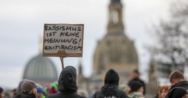 Demonstrators hold a sign reading "Racism is not an opinion! Exit: Racism" Saxony, Dresden, Oct. 28, 2025. (dpa Picture-Alliance via AFP)