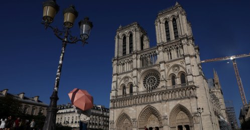 A person shelters under an umbrella outside Notre-Dame Cathedral amid a severe heat wave, Paris, France, May 26, 2026. (Reuters Photo)