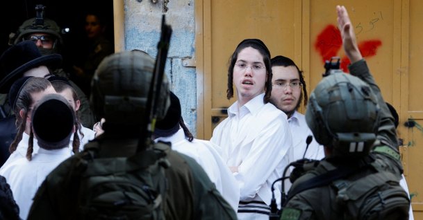 Israeli settlers stand next to Israeli soldiers during a weekly settlers' tour in Hebron, in the Israeli-occupied West Bank, Palestine, May 9, 2026. (Reuters Photo)