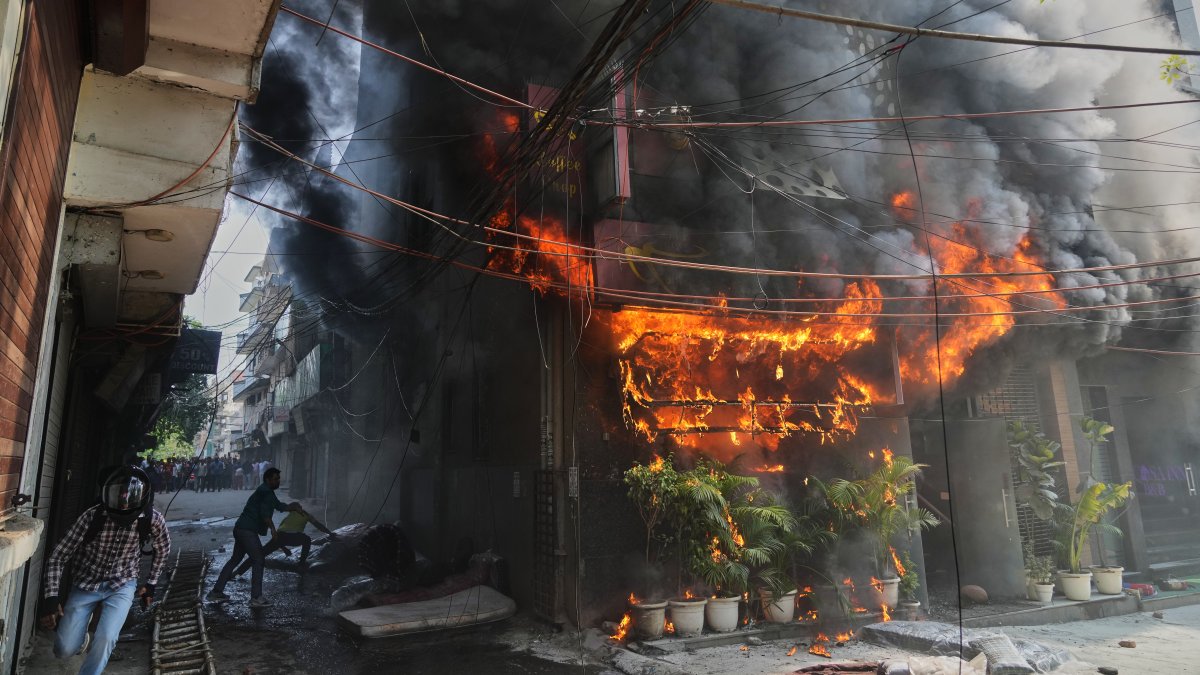Local people attempt to douse a fire at a hotel in New Delhi, India, June 3, 2026. (AP Photo)