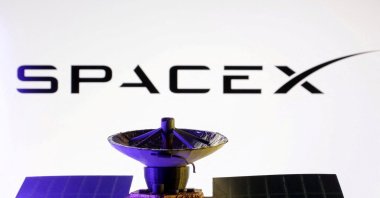 SpaceX logo and miniature satellite model are seen in this illustration taken on March 10, 2025. (Reuters Photo)