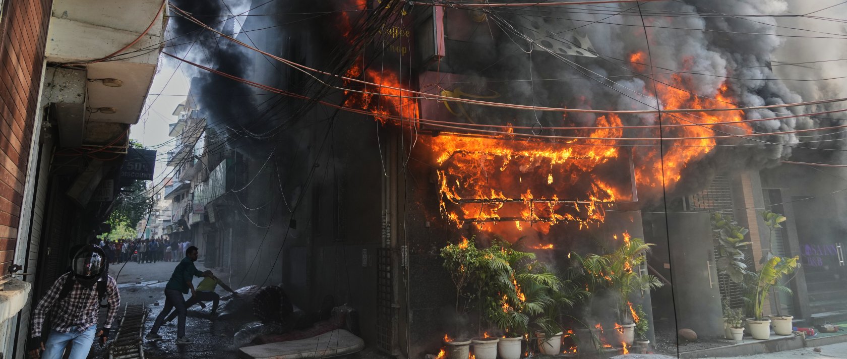 Local people attempt to douse a fire at a hotel in New Delhi, India, June 3, 2026. (AP Photo)
