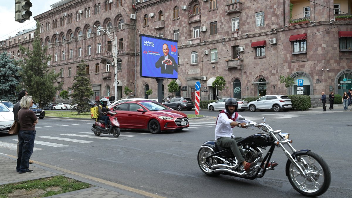 People drive past a campaign banner for the Civil Contract party, led by Prime Minister Nikol Pashinyan, ahead of the June 7 parliamentary election in Yerevan, Armenia, June 2, 2026. (Reuters Photo)