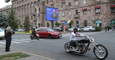 People drive past a campaign banner for the Civil Contract party, led by Prime Minister Nikol Pashinyan, ahead of the June 7 parliamentary election in Yerevan, Armenia, June 2, 2026. (Reuters Photo)