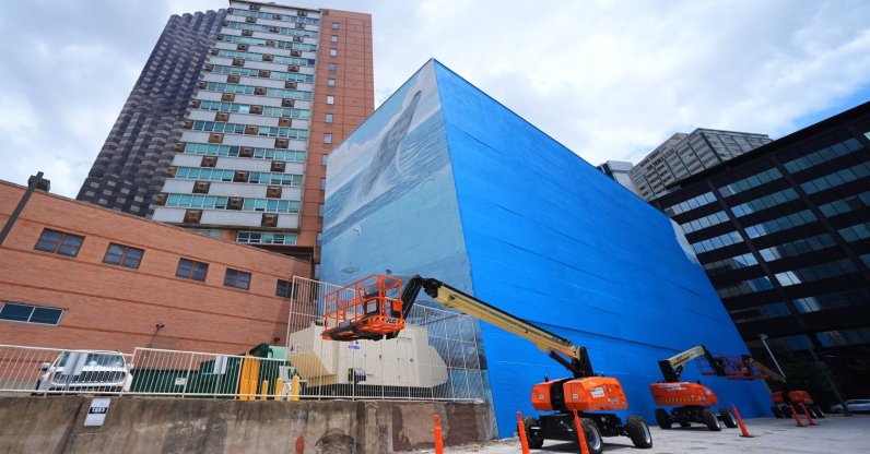 A section of a mural, known as the "Whaling Wall 82," created by artist Wyland, is visible as part of it on the right side of the building was painted over in Dallas, U.S., May 18, 2026. (AP Photo)